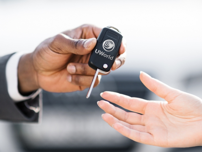 Man is handing keys over to a new car representing the “UWorld CFA exam prep test Drive”.