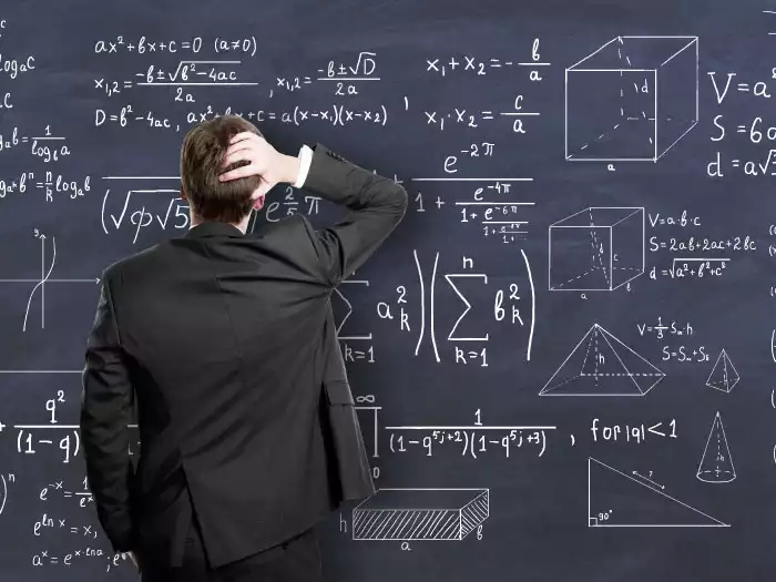 Business Man looking a board full of formulas