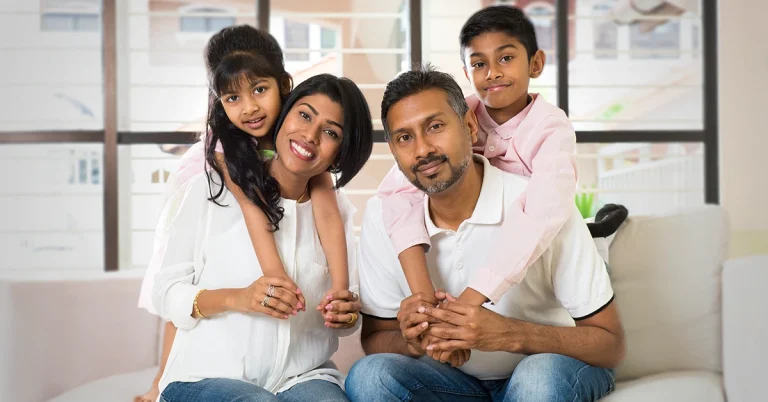 A young Indian family posing for a picture in their new home.