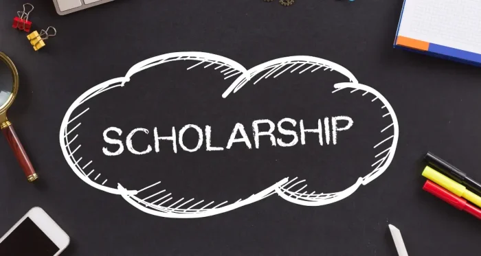 A blackboard displaying the word 'Scholarship' symbolizes the opportunity to receive financial support for the CFA® exam.