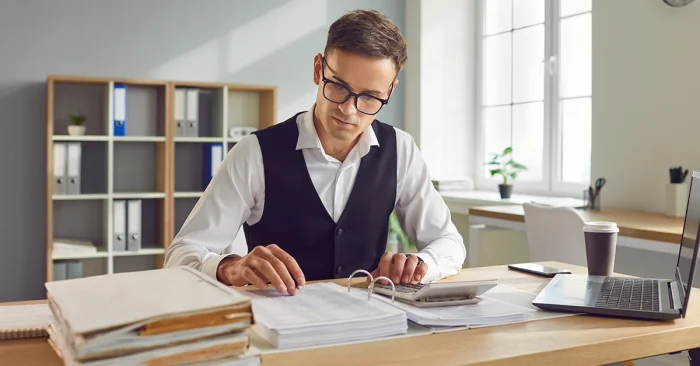 CFA candidate reviewing notes and calculations, reflecting on exam difficulty level.