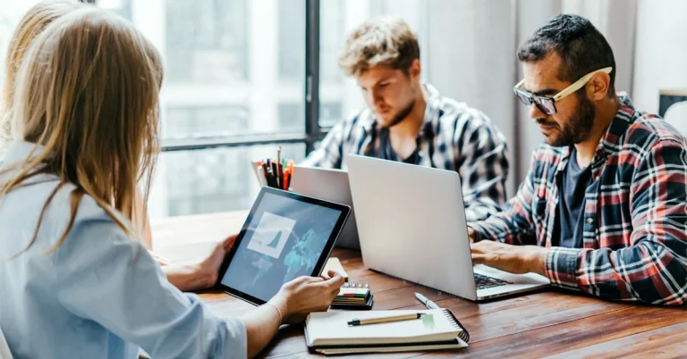 CFA candidates studying with laptops and tablet in a collaborative workspace