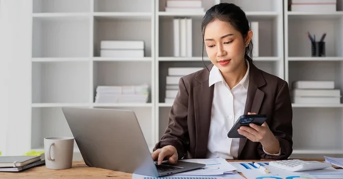 CFA charterholder working remotely while exploring job trends and opportunities on a laptop.